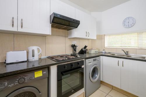 a kitchen with a washing machine and a washer at Chakas Cove in Ballito