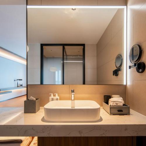 a bathroom with a white sink and a mirror at Tongpai Hotel, Zhong'an Chuanggu, Hefei High-tech Zone in Hefei