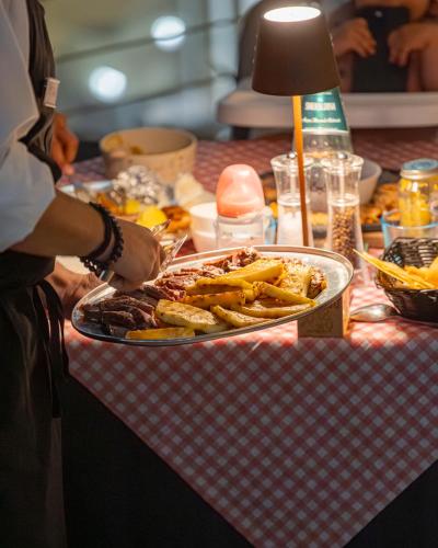 a person holding a tray of food on a table at Hotel San Teodoro in San Teodoro