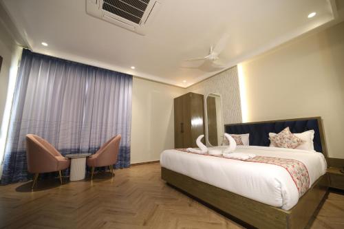 a hotel room with a bed and two chairs at Elight Inn Hotel in Jaipur