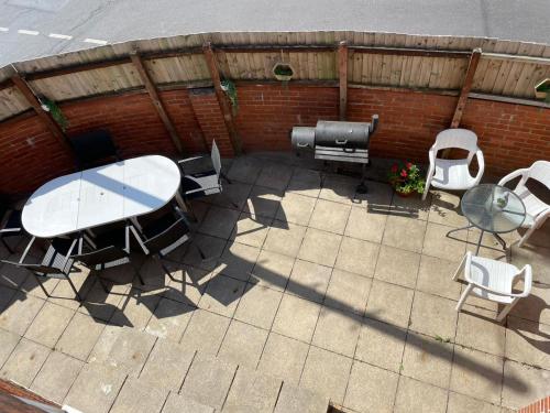 an overhead view of a patio with a table and chairs at Spacious Bournemouth Home with BBQ, Outdoor Seating & large TV in Bournemouth