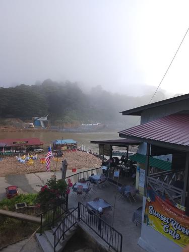 a beach with chairs and umbrellas and a building at Benteng Taman Negara in Jerantut