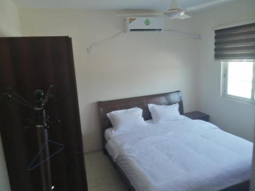 a bedroom with a bed with white sheets and a window at ميرا للشقق المفروشة Mera Apartment in Aqaba