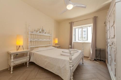 a white bedroom with a white bed and a window at Lagos Center Apartment in Lagos