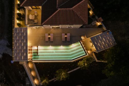 an overhead view of a house with a swimming pool at night at Majestic Stone Villa Sea View Pool in Andipáta Erísou