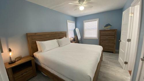 ein Schlafzimmer mit einem weißen Bett und blauen Wänden in der Unterkunft Ringling Cottage in Bailey Hall