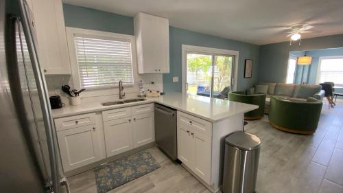eine Küche mit weißen Schränken und ein Wohnzimmer in der Unterkunft Ringling Cottage in Bailey Hall