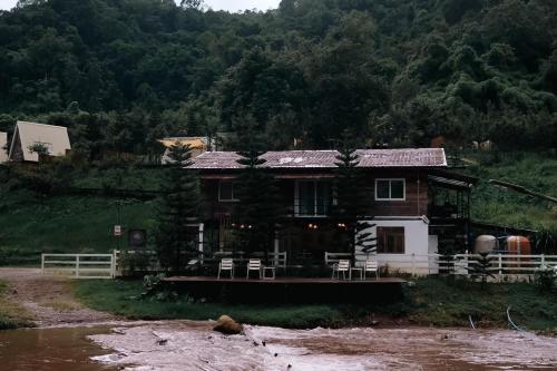 a house sitting on the side of a river at Silver Oak Valley บ่อเกลือสะปัน น่าน in Ban Kham