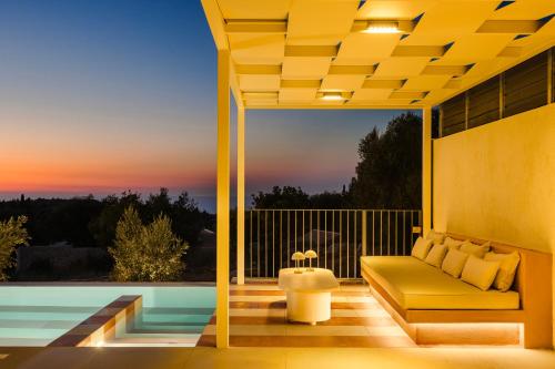 a patio with a couch and a pool at Majestic Stone Villa Sea View Pool in Andipáta Erísou