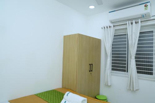 a bedroom with a cabinet and a window at Aeroview Homestay Near Chennai Airport and Rela Hospital in Chennai