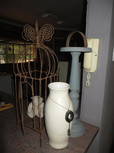 a white vase sitting on a table next to a lamp at Dandelion Cottage in Boschkop