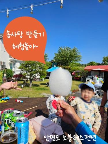 a man is holding a child in front of a table at Nobless Pension in Taean