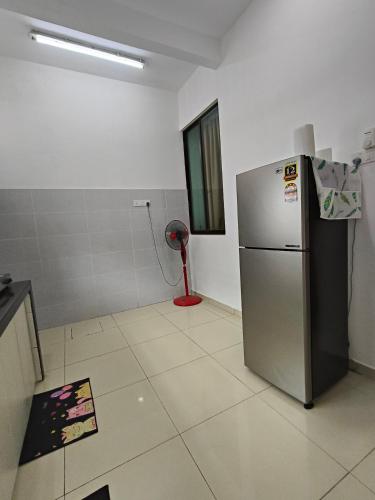 a kitchen with a refrigerator and a red fan at Bertam Wawasan Homestay in Kepala Batas