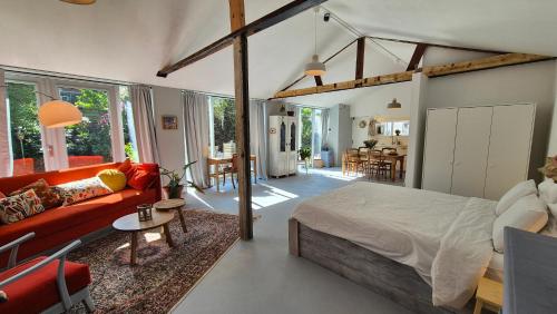 a bedroom with a large bed and a living room at Garden Studio Eindhoven in Eindhoven