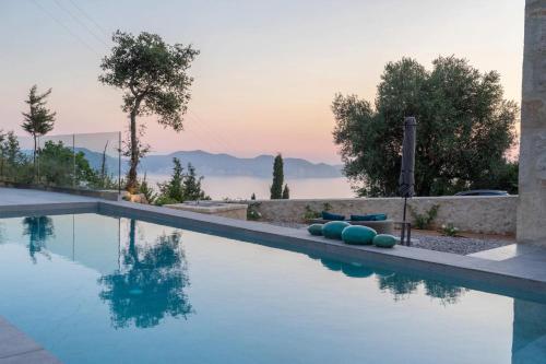 a swimming pool with a sunset in the background at Dafni by Vintage Travel in Dhefaranáta