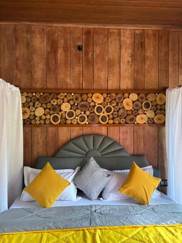a bedroom with a bed with a wooden wall at Cure Monastery Family Resort in Marayoor