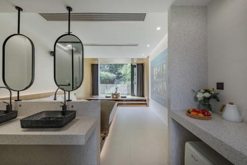 a kitchen with a sink and two mirrors at Qingcen Manor in Chiyu