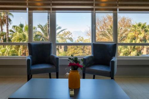 two chairs and a table in a room with windows at Sea View Flat in Kaleici Old Town Near Sea Park in Antalya