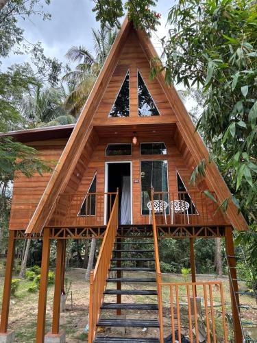 a tree house with a staircase leading up to it at Cure Monastery Family Resort in Marayoor
