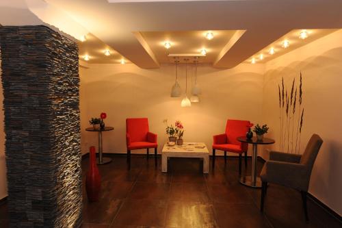 a waiting room with red chairs and a table at Altstadt-Hotel in Freiberg