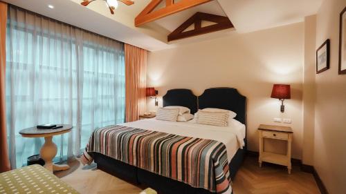 a bedroom with a bed and a large window at Sugar Marina Hotel-SURF-Kata Beach in Kata Beach