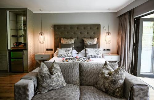a living room with a couch in front of a bed at Silver Forest Boutique Hotel and Spa in Somerset West