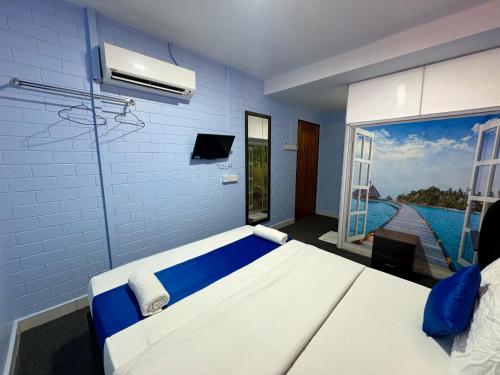 a blue room with a bed and a window at Gemilang Star Hotel in Port Dickson