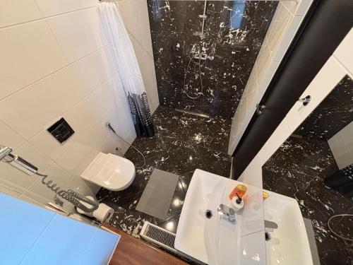 a bathroom with a sink and a shower and a toilet at ApartHotel Riga in Rīga