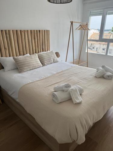 a bedroom with a large bed with towels on it at Mar de Ría 2 in Ribeira