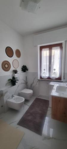 a bathroom with two sinks and a toilet and a window at L'Ulivo in Povegliano Veronese