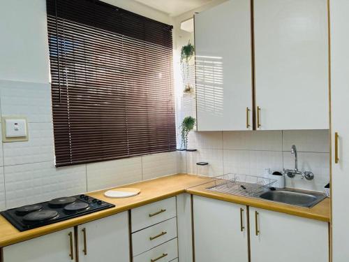 a kitchen with white cabinets and a sink at Casa Myla, 2 Kuiseb Street, Windhoek in Windhoek