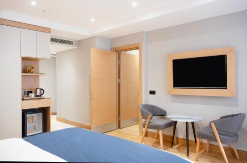 a bedroom with a tv and two chairs and a table at Pera Star Hotel in Istanbul