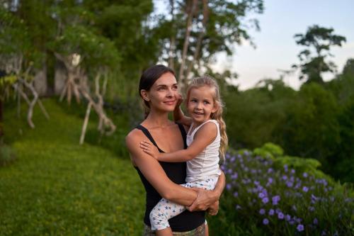 a woman holding a little girl in a park at The Westin Resort & Spa Ubud, Bali in Ubud