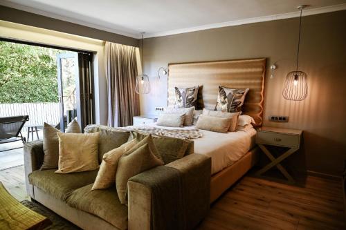 a bedroom with a large bed and a couch at Silver Forest Boutique Hotel and Spa in Somerset West