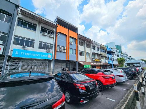 a parking lot with cars parked in front of a building at Propeller Airplane Riverview Kuching Homestay in Kuching