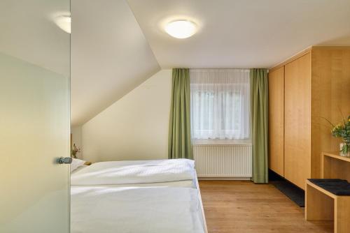 a small room with a bed and a window at Hotel OXA - Easy Escape in Hittisau