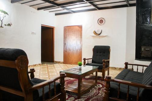 a living room with two chairs and a table at The Aurora Coorg in Madikeri