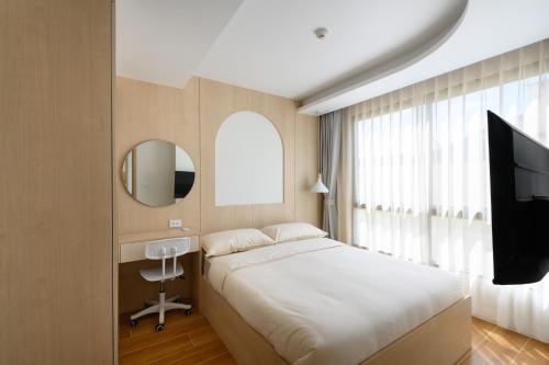 a bedroom with a bed and a flat screen tv at Fantasea Condo Kamala A209 2BDRM by Phuket Sabay Rent in Kamala Beach