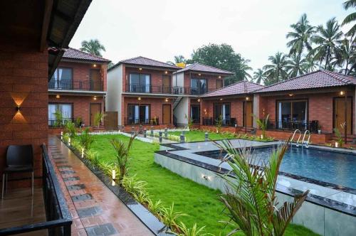 a resort with a swimming pool and a resort at Shivani Sunset Bay Beach Resort in Māvalli