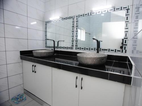 a bathroom with two sinks and a mirror at Nyali one bedroom Villa- Subree Luxury in Mombasa