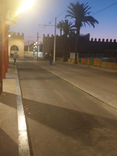 eine leere Straße mit Palmen und einem Straßenlicht in der Unterkunft La gare agdal in Rabat