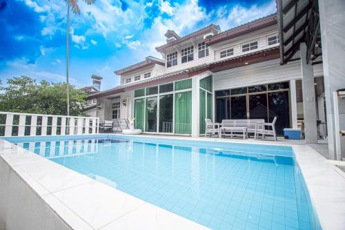 a swimming pool in front of a house at Triple Trees A15 House Khao Yai in Mu Si