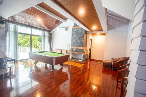a living room with a pool table and a fireplace at Triple Trees A15 House Khao Yai in Mu Si