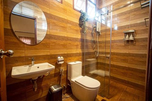 a bathroom with a toilet and a sink and a mirror at Triple Trees A15 House Khao Yai in Mu Si