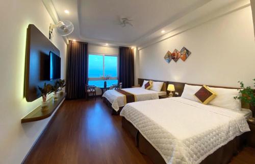 Una habitación de hotel con dos camas y vista al mar. en Hải Hòa Victoria Hotel, en Nghi Sơn