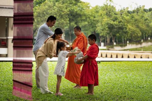 a group of people standing around in a park at Le Meridien Chiang Rai Resort, Thailand in Chiang Rai
