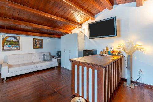 a living room with a couch and a tv on the wall at 3 Twins Suite Portopalo in Portopalo
