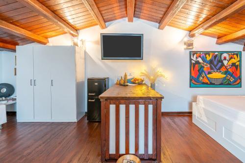 a living room with a tv on the wall at 3 Twins Suite Portopalo in Portopalo
