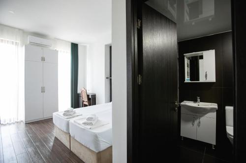 a bathroom with a white bed and a sink at kutaisi hostel hub in Kutaisi