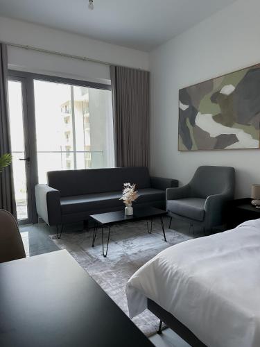 une chambre avec un lit, un canapé et une table dans l'établissement Bright & Modern Studio Masdar City, Abu Dhabi, à Abu Dhabi